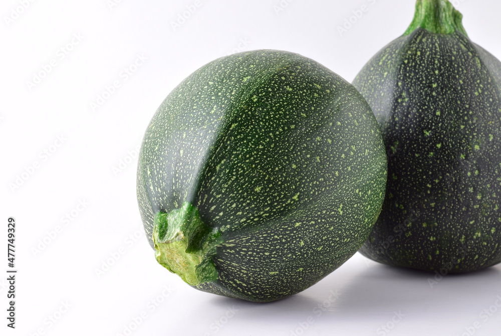 Front shot, round zucchini on light background. Copy space. Front shot, round zucchini on light background. Copy space.