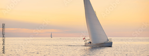 Fotografie, Obraz White sloop rigged yacht sailing in the Baltic sea at sunset