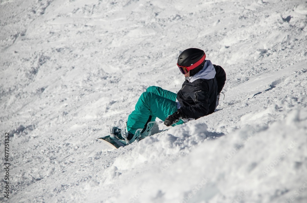 a girl on a snowboard rides down the side of the mountain a girl on a snowboard rides down the side of the mountain
