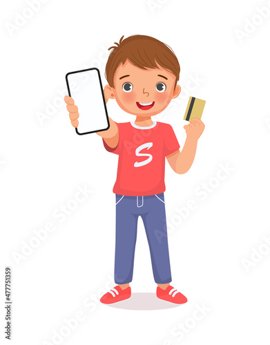 Cute little boy showing mobile phone with blank screen and holding credit card for making online payment