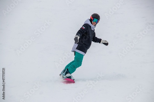 a girl on a snowboard rides down the side of the mountain