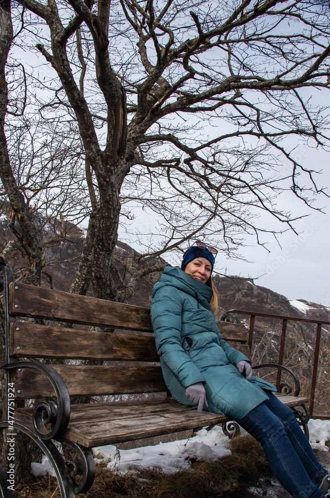 Girl on a bench under a tree on top of a mountain Girl on a bench under a tree on top of a mountain