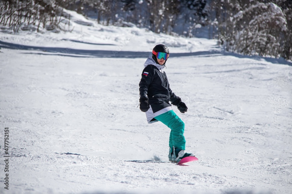 a girl on a snowboard rides down the side of the mountain