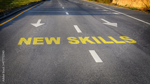 New skills word and white arrow on asphalt road. Reskilling and upskilling development concept and changing skill demand idea