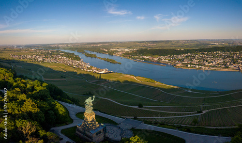 Luftaufnahme mit Drohne vom Niederwalddenkmal und Weinbergen bei Rüdesheim am Rhein während des Sonnenuntergangs and einem teilweise bewölkten Tag im Sommer, Rheingau Hessen photo