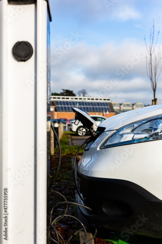 Electric car charging at plug in charge station in a public car park in Suffolk, UK © Collins Photography