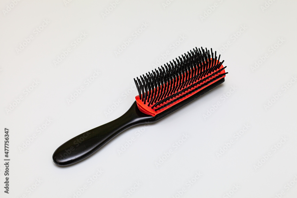 simple plastic comb black red on gray background simple plastic comb black red on gray background