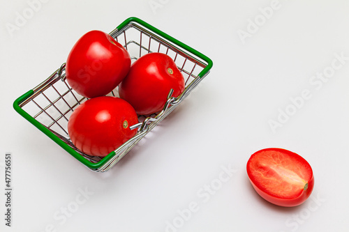 miniature grocery basket with tomatoes on a white background photo