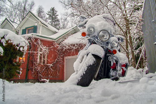 Motorcycle under the snow on winter parking