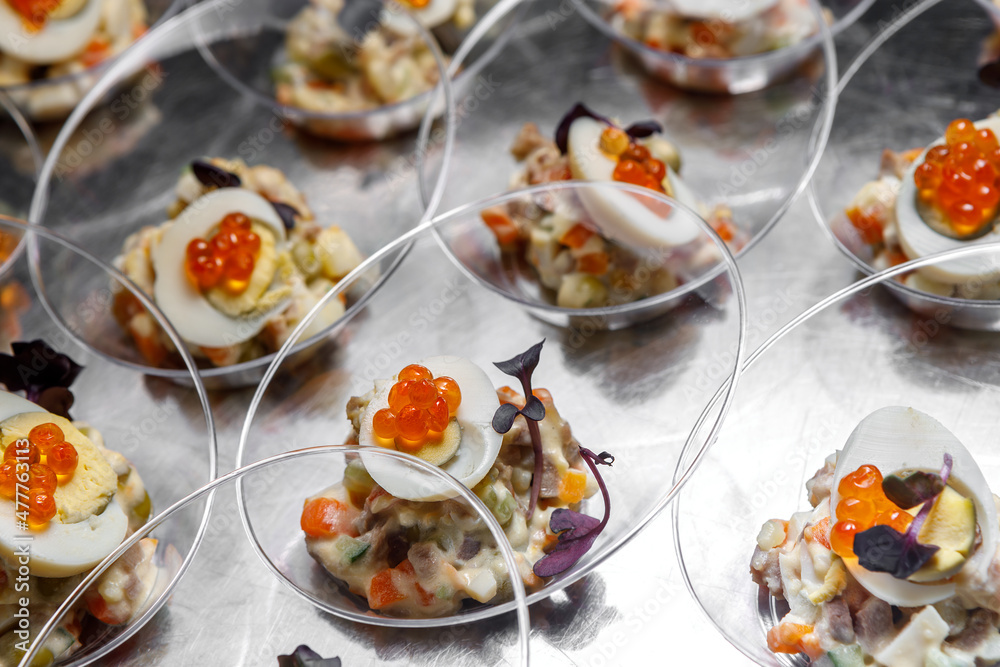Light meat appetizer and chicken egg with red caviar and herbs in transparent cups on the table. Light meat appetizer and chicken egg with red caviar and herbs in transparent cups on the table.