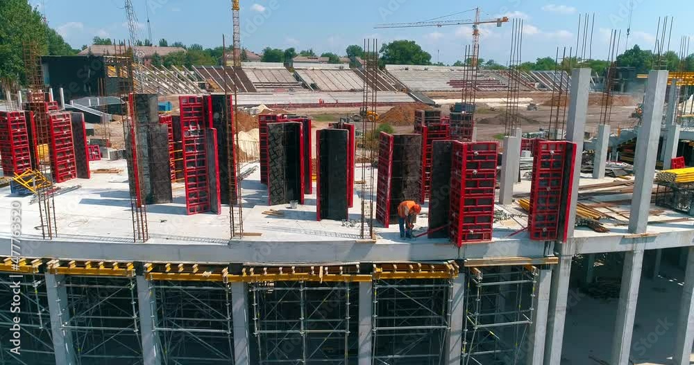 Builders make formwork at the construction site of a new stadium