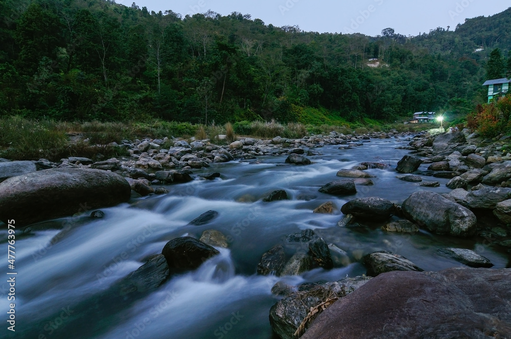 View of slow shutter speed water , Reshi River water flowing on rocks at dusk, Sikkim, India. Himalayan mountains. View of slow shutter speed water , Reshi River water flowing on rocks at dusk, Sikkim, India. Himalayan mountains.