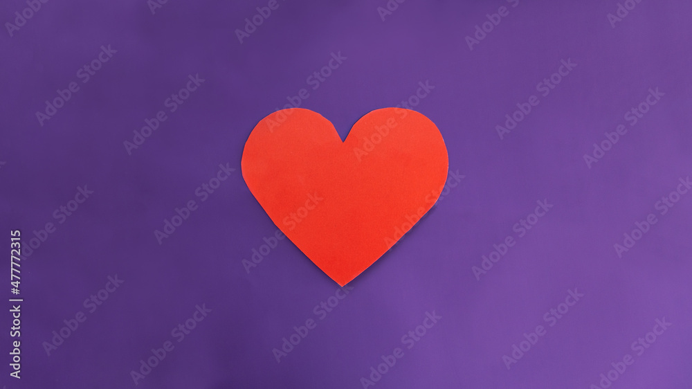 card in the form of a red heart and flowers in a white envelope on a textured blue background. Selective focus.