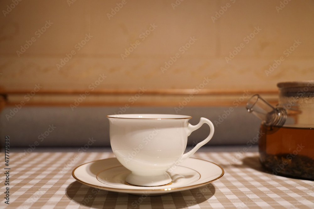 Obraz premium White porcelain cup and saucer with tea on the table