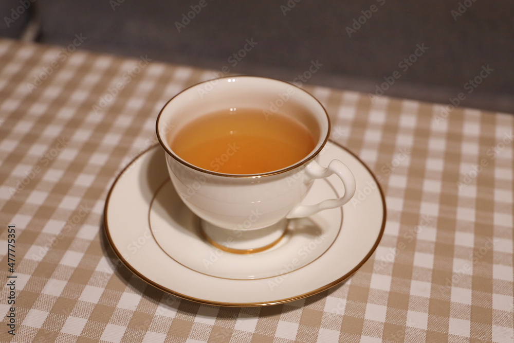 White porcelain cup and saucer with tea on the table White porcelain cup and saucer with tea on the table