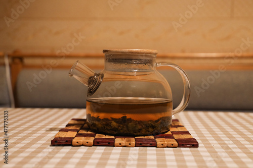 Transparent teapot with freshly brewed green tea with rice