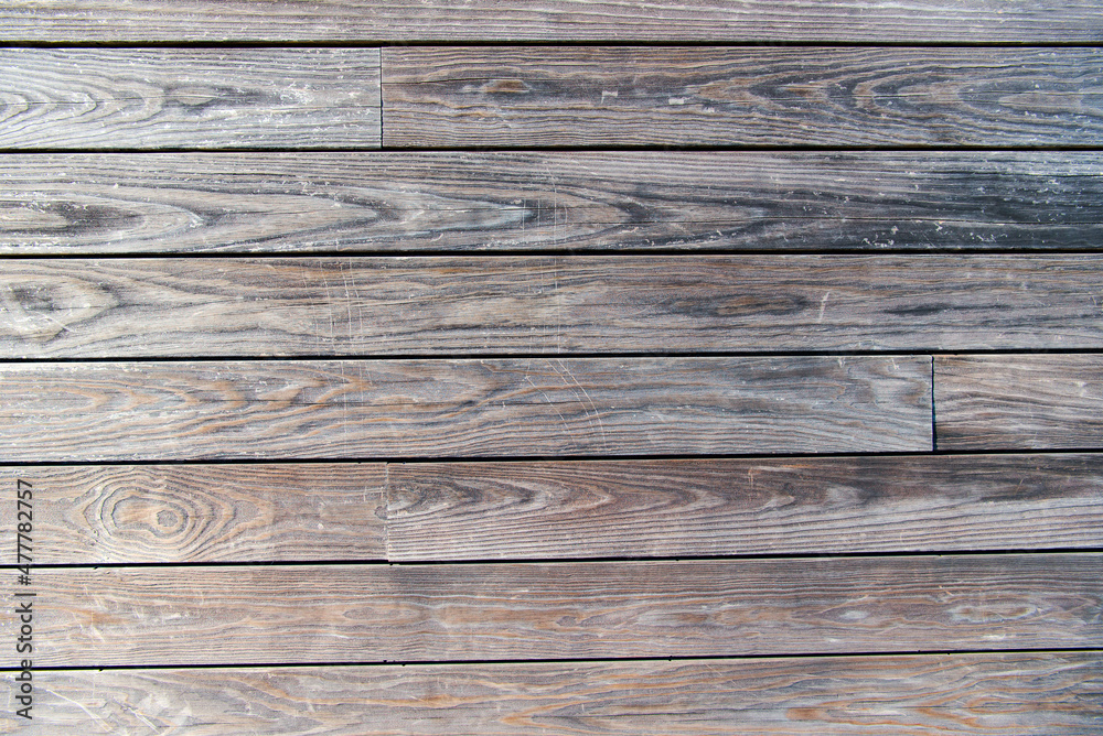 Gray wood texture background. The wooden boards are laid horizontally and have a worn look. Gray wood texture background. The wooden boards are laid horizontally and have a worn look.