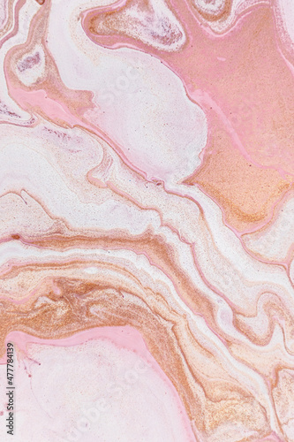 Abstract background in pink and orange with marble texture from closeup of acrylic pour art