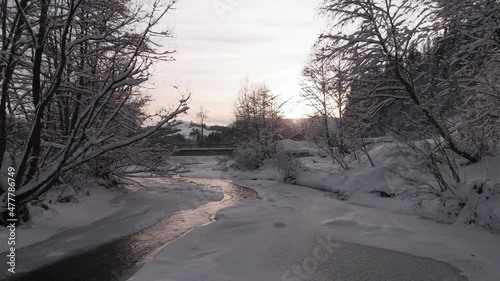Winter in the mountains. Forest in the snow. Frozen mountain river. Shooting from a quadcopter.