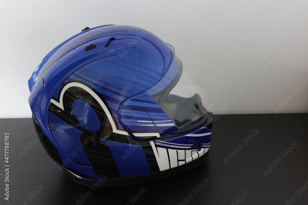 Fototapeta premium Motorcycle helmet in a blue, black, white color on a gray background