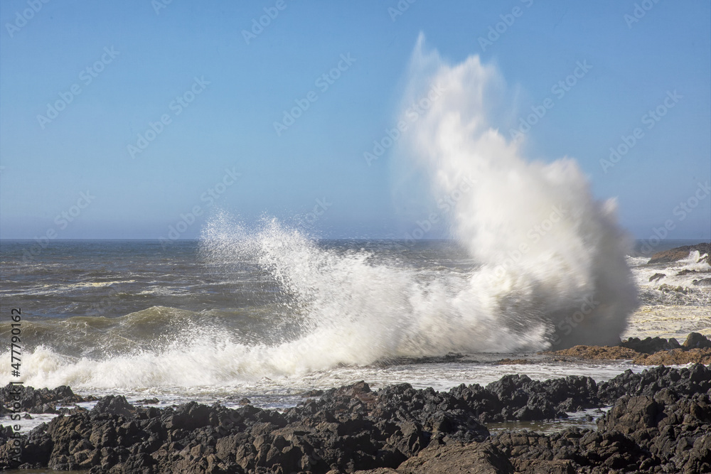 An original nature photograph of giant waves crashing against a rocky shoreline 