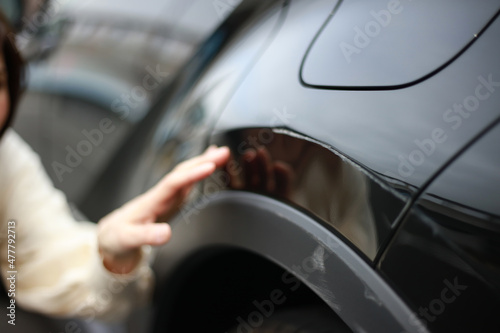  車の傷を確認する女性