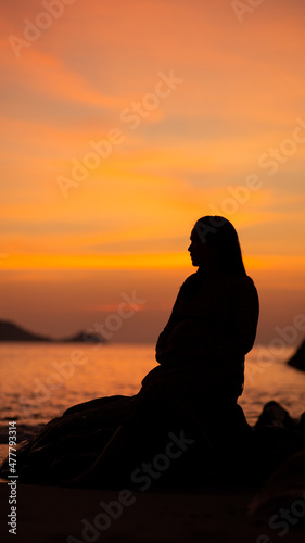 silhouette of a person sitting on a bench, sunset over the river, Patong beach