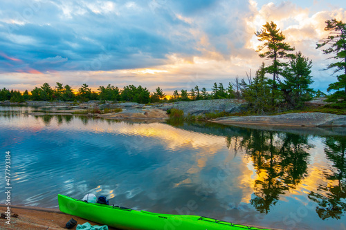 Canvas Print Sunset seen  on a rocky campsite on Georgian Bay, Ontario Canada with a green kayak in the foreground