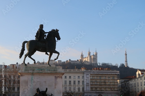View of the equestrian statue of louis xiv and the basilica of notre dame de fourviere from place bellecour, in the center of Lyon, France. photo