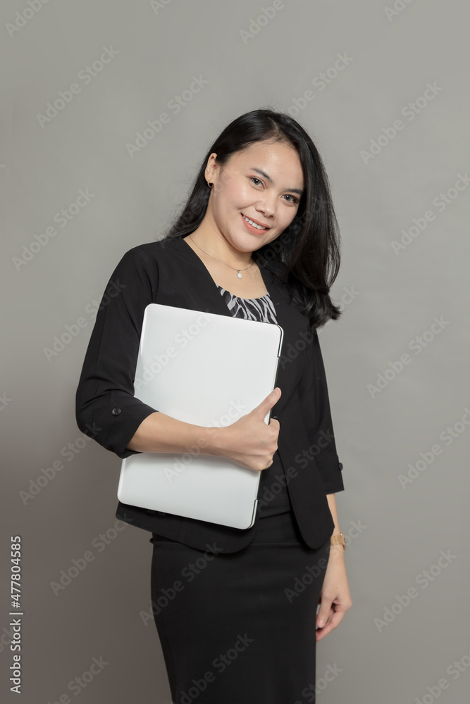 Beautiful woman posing while holding laptop Beautiful woman posing while holding laptop