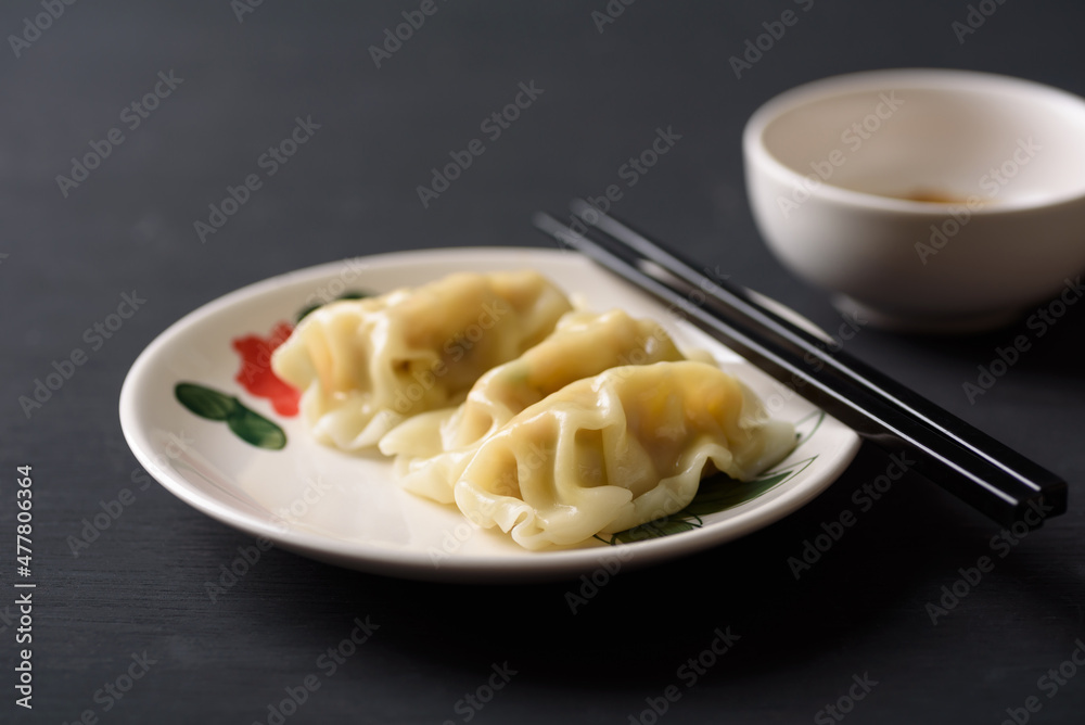 Wonton stuffed, gyoza or dumplings, Asian cultural food on black background Wonton stuffed, gyoza or dumplings, Asian cultural food on black background