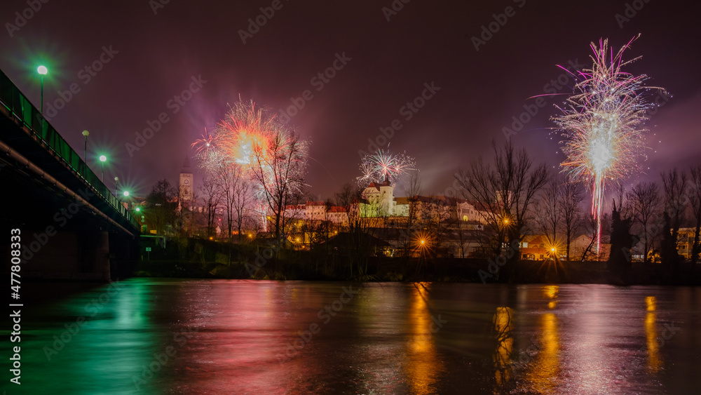 silvester fireworks over enns, upper austria, seen from ennsdorf with the river enns