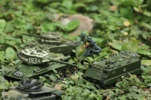 Miniature infantry and tank cavalry are being stationed in the forest. Jungle battlefield camouflaged with army uniform.