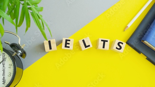 On wooden blocks under text: IELTS. IELTS words from wooden blocks with letters, International English Language Testing System IELTS exam concept