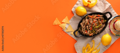 Foto Baking dish with tasty Mexican Fajita on orange background with space for text