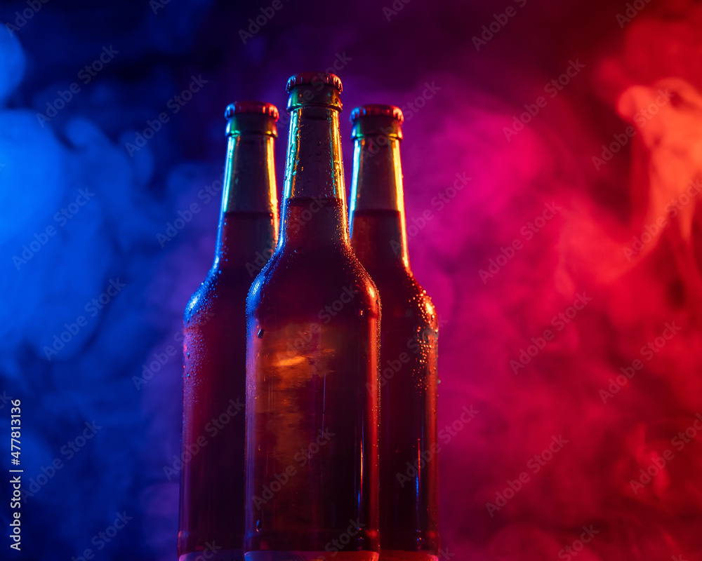 Three bottles of beer in a blue-pink mist. Three bottles of beer in a blue-pink mist.