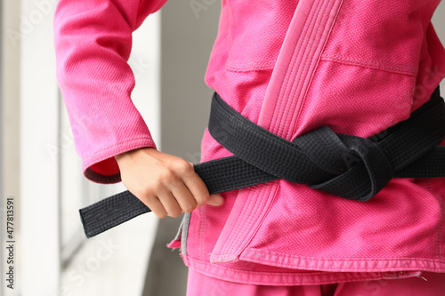 Young woman practicing karate in gym, closeup photo