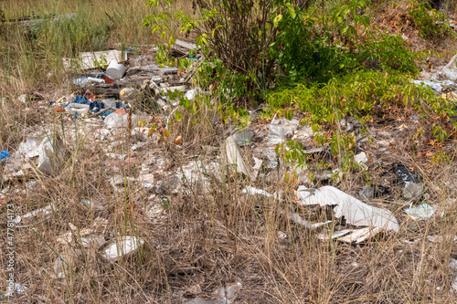 Plastic garbage, lying in the forest, among grass and bushes