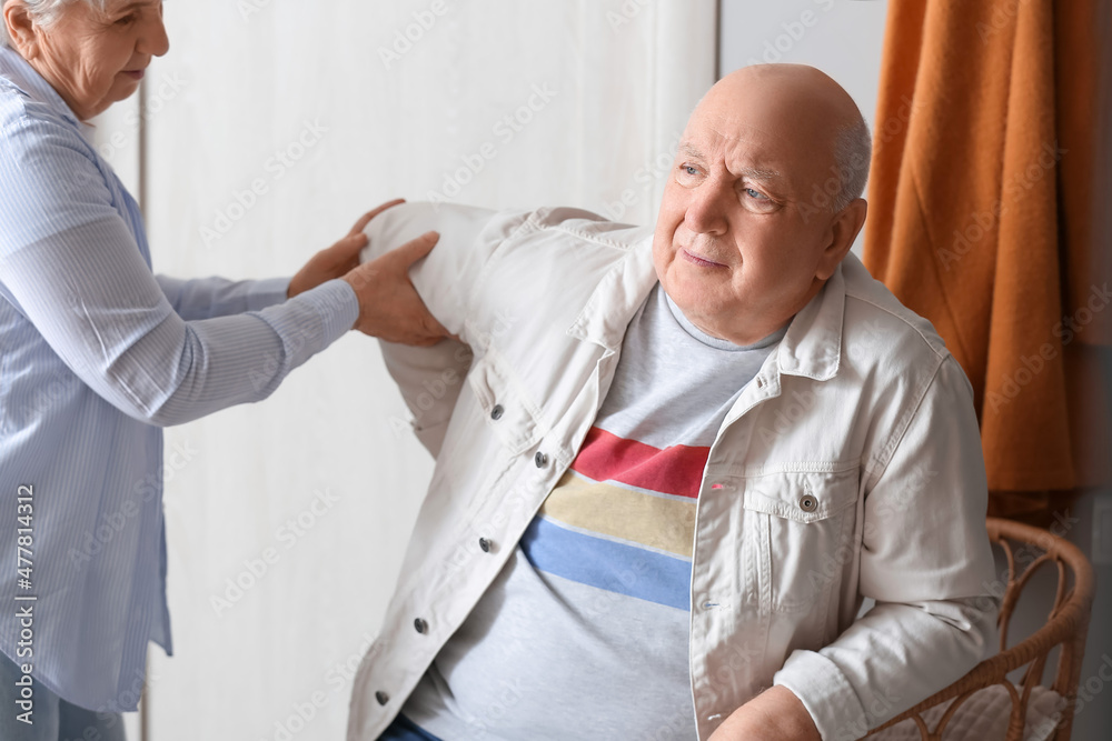 Obraz premium Senior man suffering from back pain and his wife at home