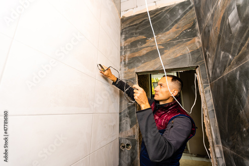 repair, renovation, electricity and people concept - of electrician hands