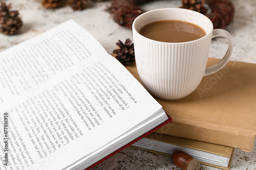 Cup of tasty coffee and books on light background