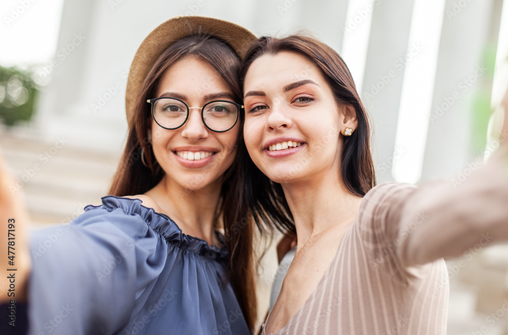 Two young women take a selfie together and have fun in the city. Two young women take a selfie together and have fun in the city.