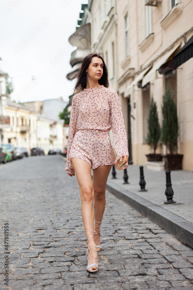 Young fashion woman with stylish sundress on a European street