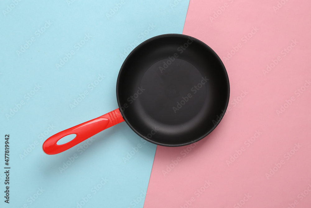 Empty toy plastic frying pan on blue pink pastel background Empty toy plastic frying pan on blue pink pastel background