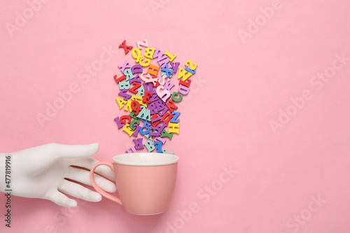 Fotografering Wooden hand holding Cup with letters on a pink pastel background