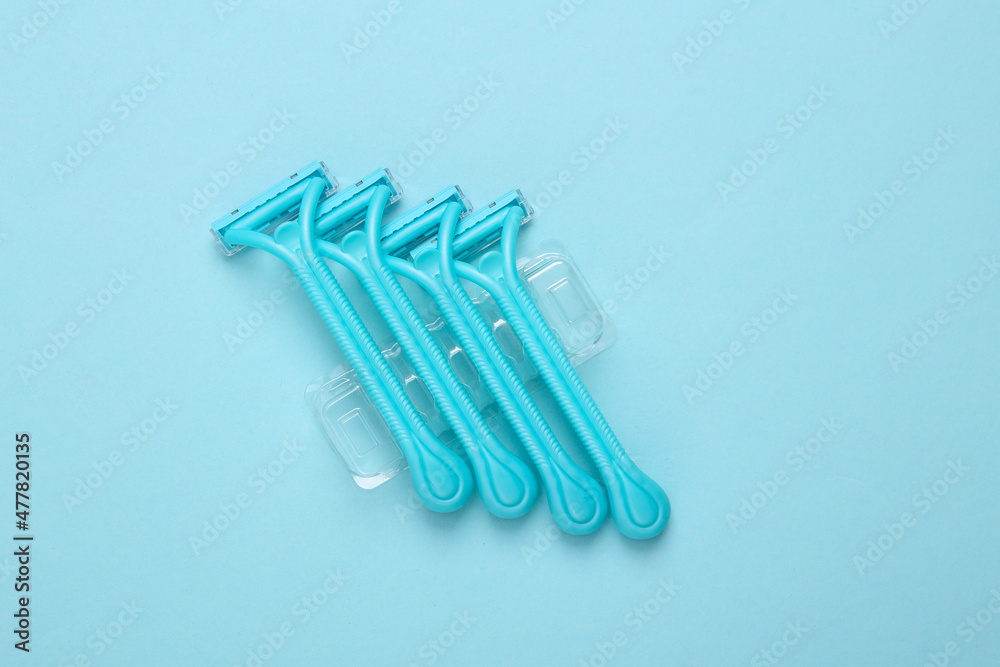 Set of disposable razors for depilation on blue background. Top view Set of disposable razors for depilation on blue background. Top view