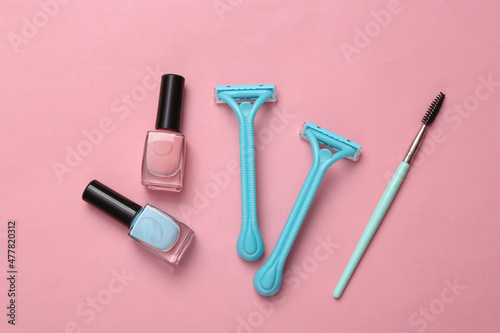 Fototapeta Naklejka Na Ścianę i Meble -  Depilatory shaver, nail polish and makeup brush on pink background. Top view