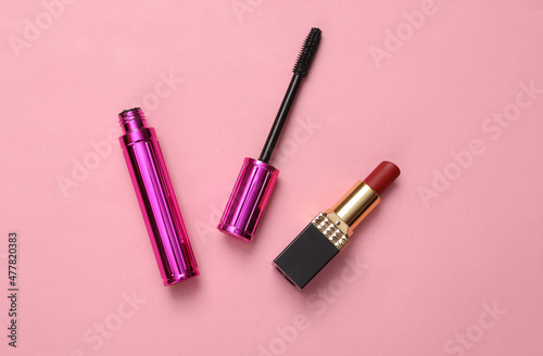 Eyelash brush with mascara and lipstick on pink background, beauty concept