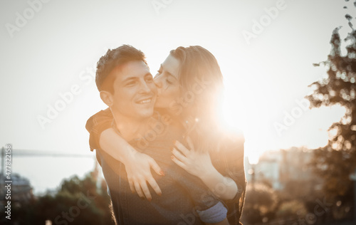 Young couple in love. Smiling girl with her boyfriend hugging at sunrise in the city