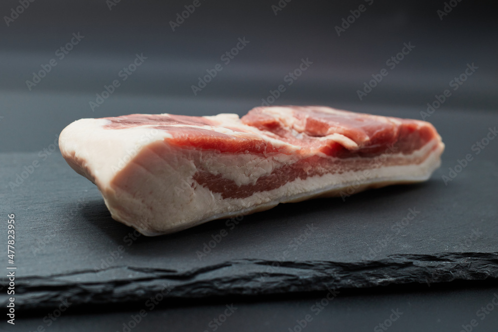 黒い平皿にのったブロックの豚バラ肉 黒い平皿にのったブロックの豚バラ肉